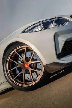 Side profile showcasing the aggressive flush fender fitment of 5x120 Matte Bronze BBS RIA wheels on an M2
