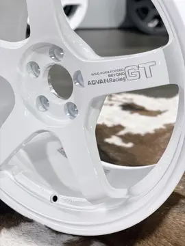Close up detailing the authentic 3D machined Advan Racing GT Beyond logo lettering on a glossy white spoke