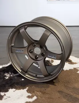 Low angle dynamic view of an 18 inch RAYS TE37 Saga SL wheel in Matte Gun Bronze finish