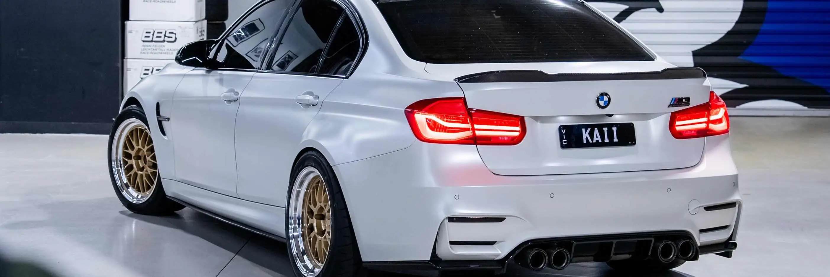 Alpine White BMW F80 M3 sedan fitted with Volk Racing 21A wheels featuring Gold face and polished silver rim