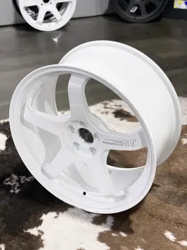 Detailed product shot focusing on the central hub drop and structural weight saving lug pockets of a standalone Racing White wheel
