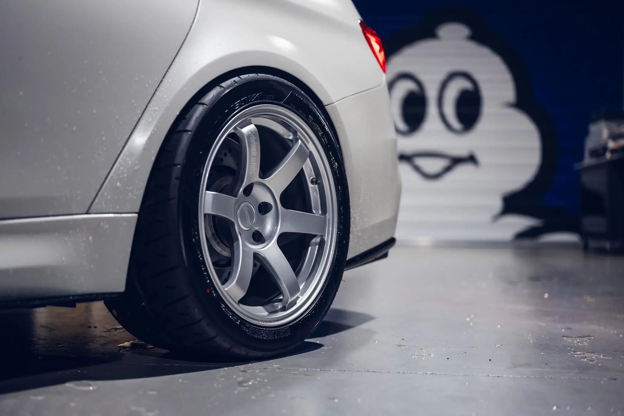Rear three quarter view of a white BMW F80 M3 highlighting the aggressive concave face of Diamond Silver TE37 rear wheels