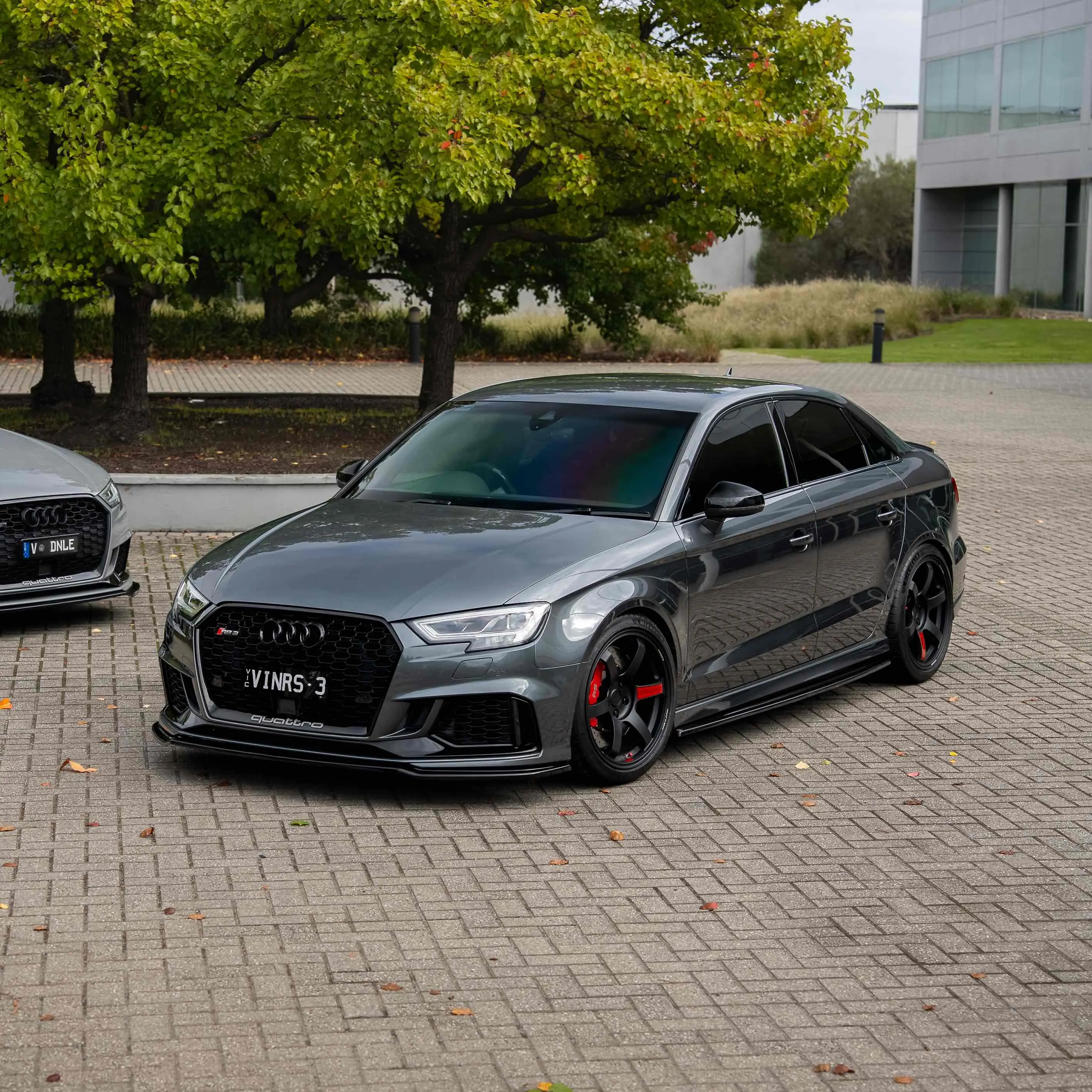 Daytona Grey Audi RS3 8V sedan featuring matte black RAYS Volk Racing TE37 Saga SL forged wheels in 18x9.5 +45 with red stickers