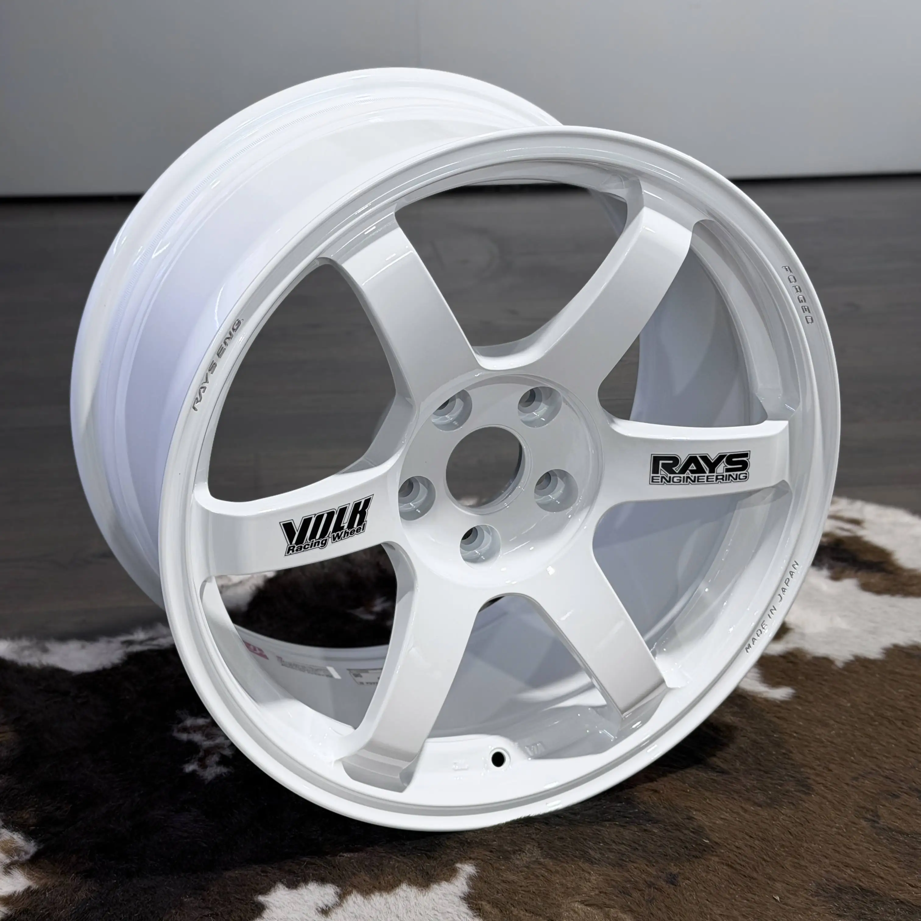 Three quarter view of a Dash White 18 inch TE37 Saga SL highlighting the genuine black RAYS decal contrast