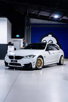 Low angle rear perspective of Alpine White F80 M3 showing concave Gold face Volk Racing 21A fitment