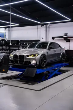 Aggressive front end profile of a BMW G80 M3 featuring gloss black forged monoblock TE37 wheels