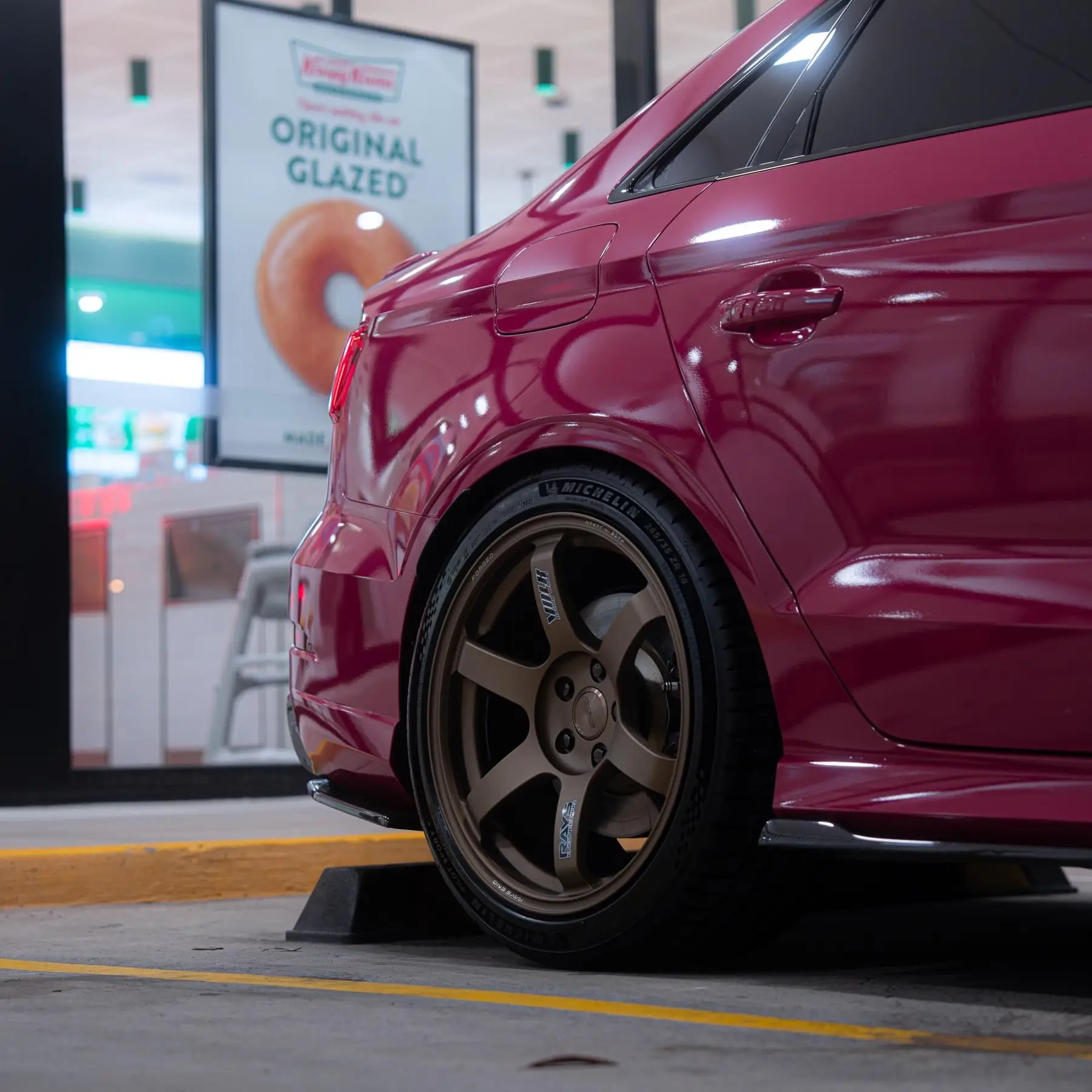 Rear profile of Ruby Star Pink Audi 8V RS3 Sedan with 5x112 Matte Gun Bronze RAYS Volk Racing TE37 SAGA SL wheels from KA Autosport