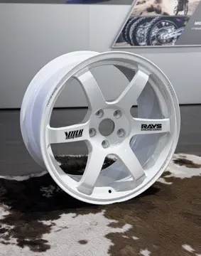 Close up of the authentic black RAYS engineering spoke sticker on an 18 inch forged white TE37 wheel