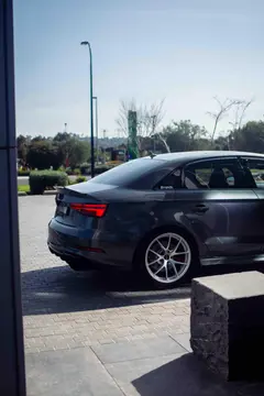 Three quarter aggressive stance view of an Audi RS3 showcasing a Diamond Silver BBS RIA setup