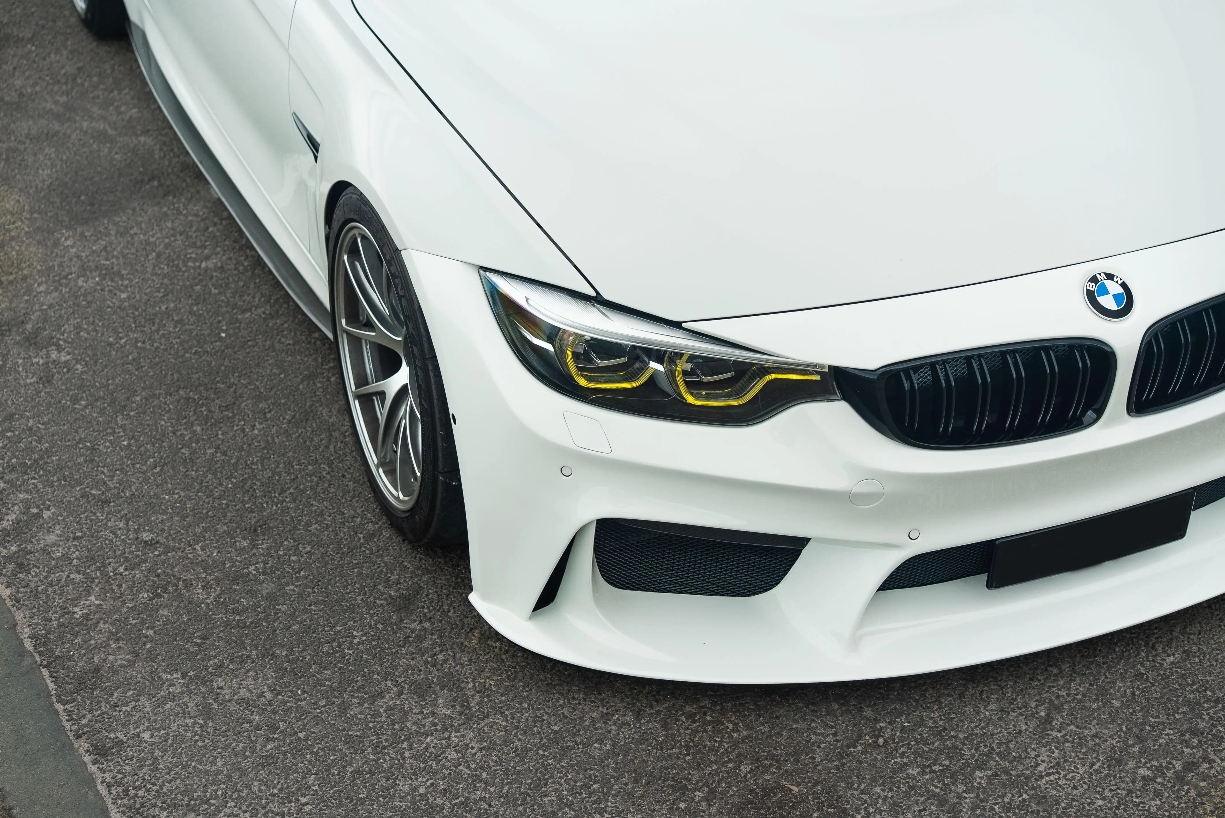 Three quarter stance view of an Alpine White F80 M3 showcasing a Diamond Silver BBS RIA setup