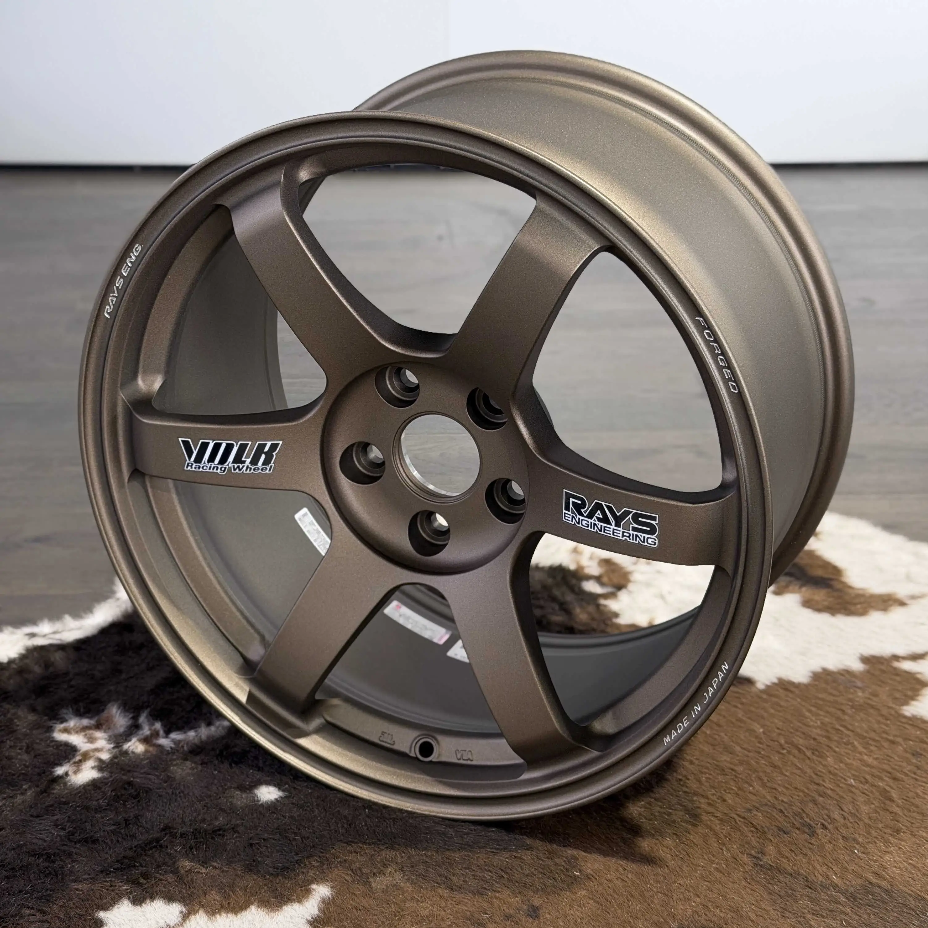 Low angle dynamic view of an 18 inch RAYS TE37 Saga SL wheel in Matte Gun Bronze finish