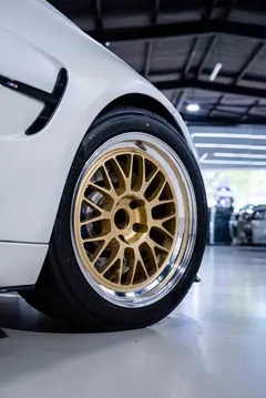Detailed shot of the gold mesh spoke design and central hub machining on a RAYS Volk Racing 21A wheel