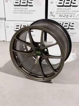 Side angle view illustrating the deep center drop and lightweight brake clearance architecture of a Matte Bronze RIA wheel