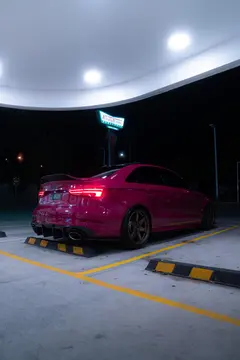 Aggressive low-angle view of Ruby Star Pink Audi RS3 8V equipped with Matte Gun Bronze RAYS Volk Racing TE37 SAGA SL wheels