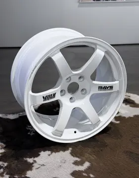 Three quarter view of a Dash White 18 inch TE37 Saga SL highlighting the genuine black RAYS decal contrast