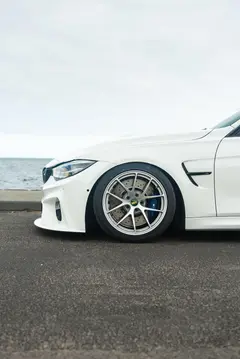 Rear three quarter perspective emphasizing the deep barrel profile of wide Diamond Silver BBS RIA rear wheels on a white M3