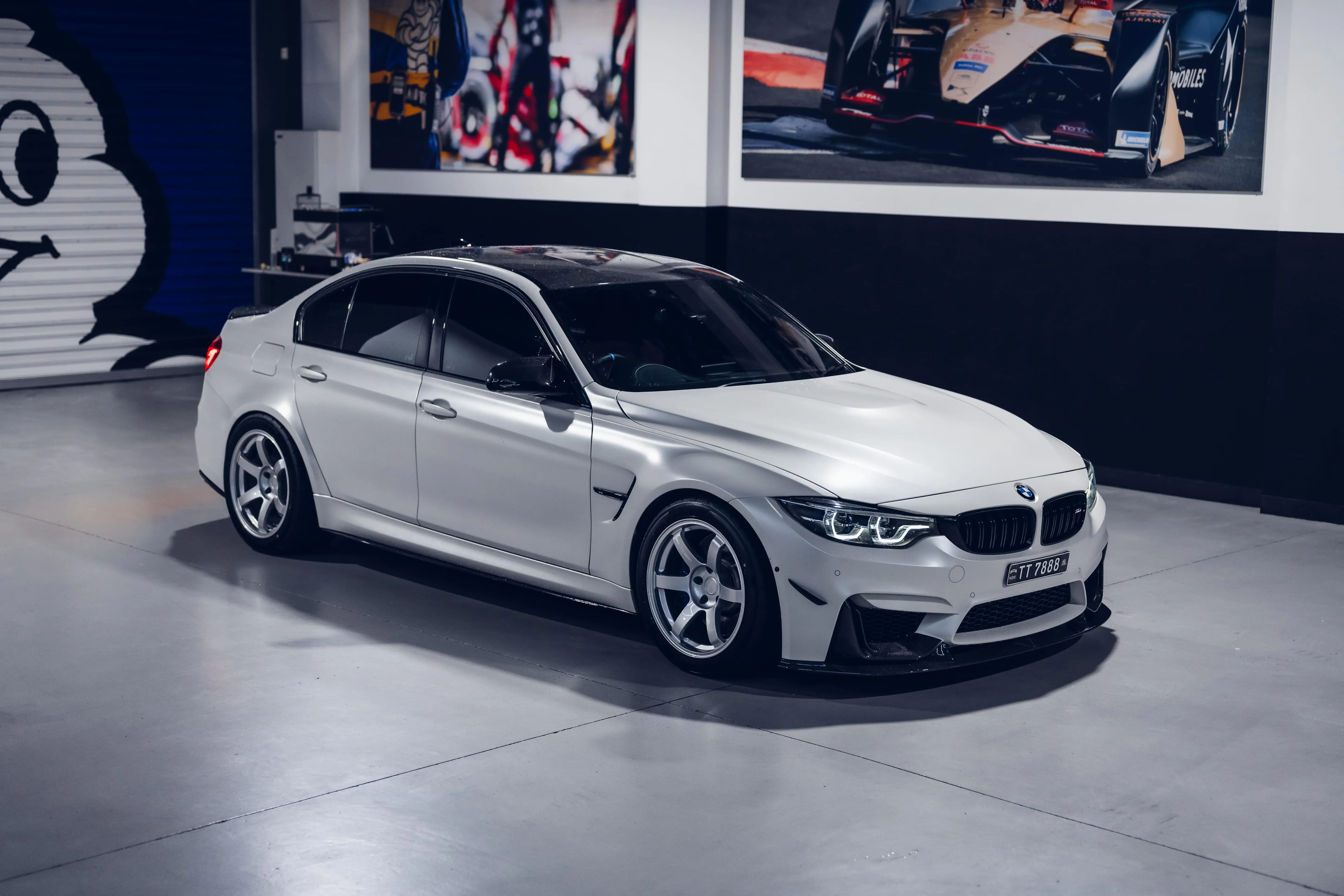 Aggressive track stance of a white BMW F80 M3 showcasing lightweight Japanese forged Diamond Silver TE37 wheels